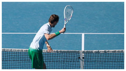 Daniil Medvedev reacts to breaking the net camera with his tennis racket after Australian Open opening round